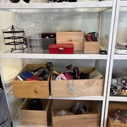 Houten opbergkisten en dozen met verschillende spullen op schappen in de winkel