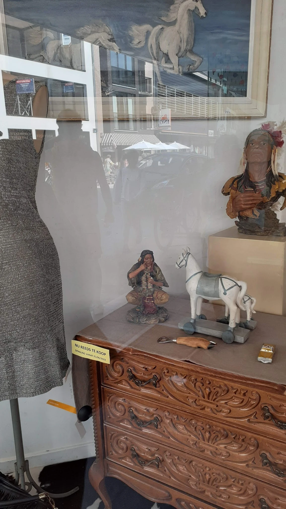Vitrinekast met diverse decoratieve artikelen: beelden, servies en kleine voorwerpen