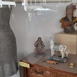 Vitrinekast met diverse decoratieve artikelen: beelden, servies en kleine voorwerpen