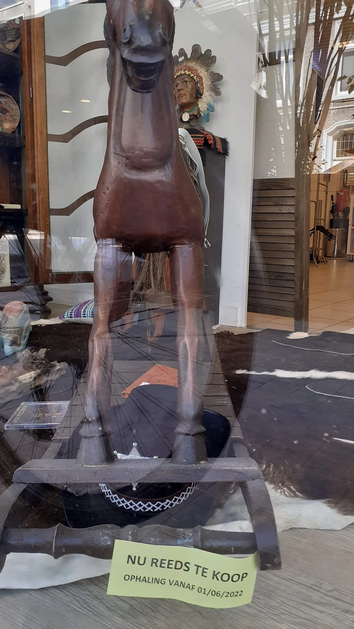 Bruin houten meubel met uitstekende delen, mogelijk een kapstok of hoekkast, in een winkelinterieur
