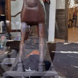 Bruin houten meubel met uitstekende delen, mogelijk een kapstok of hoekkast, in een winkelinterieur
