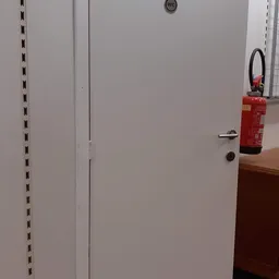 Witte deur met brandblusser aan de muur in een winkelruimte
