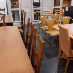Winkelvloer met diverse stoelen en tafels, voorzijde van de kringloopwinkel