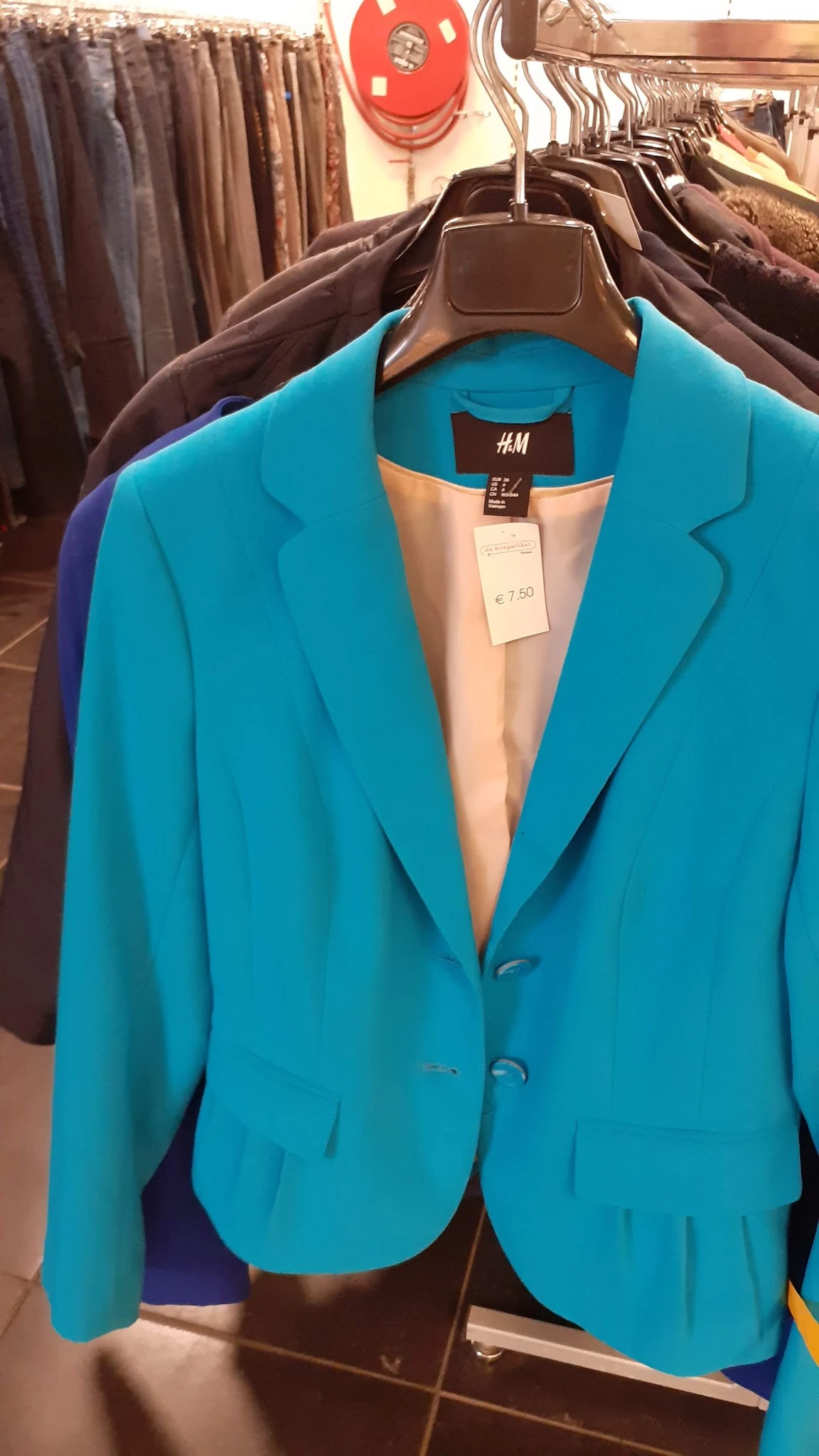 Turquoise blazer van H&M met prijskaartje van €7,50