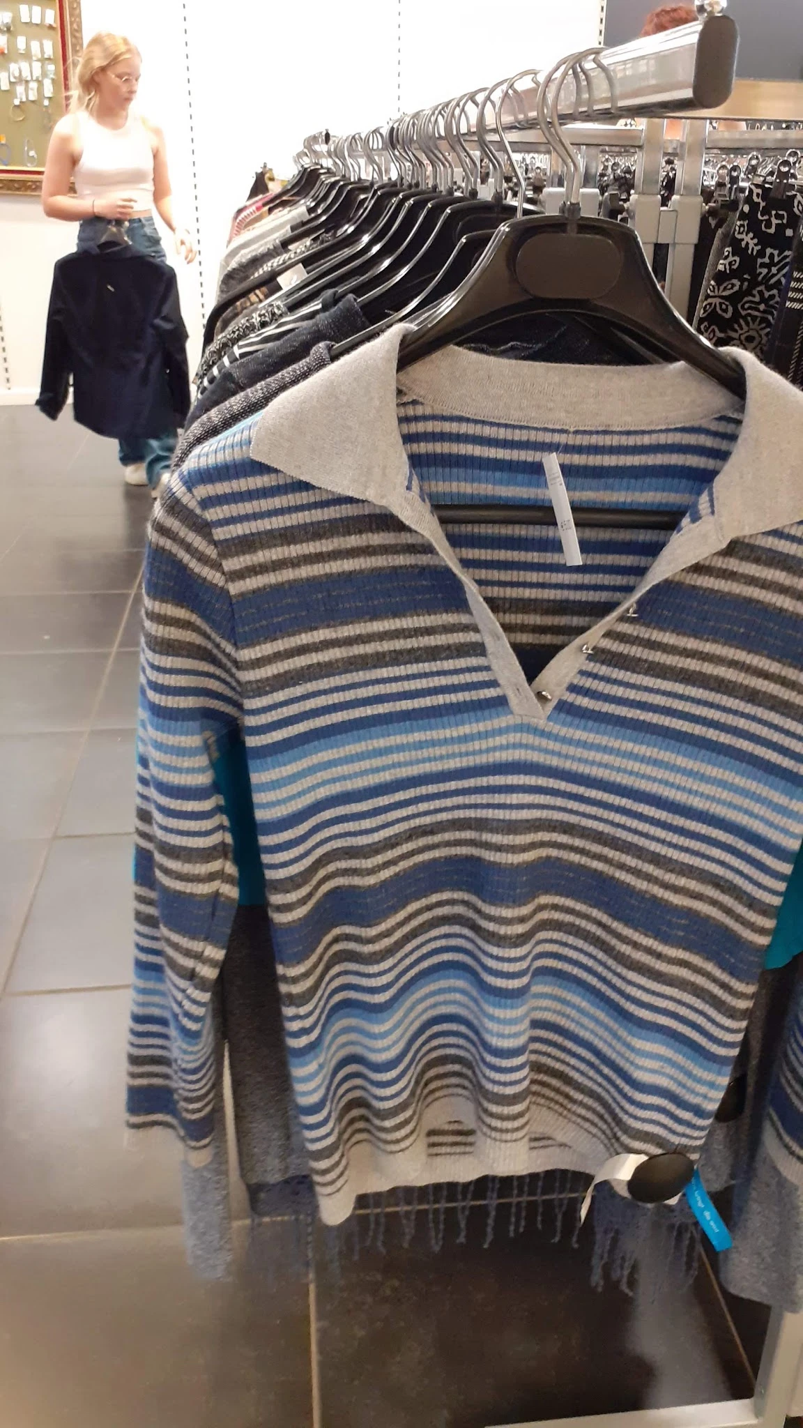 Close-up van een gestreepte trui in blauwe, grijze en witte kleuren met witte kraag