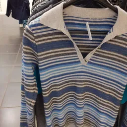 Close-up van een gestreepte trui in blauwe, grijze en witte kleuren met witte kraag