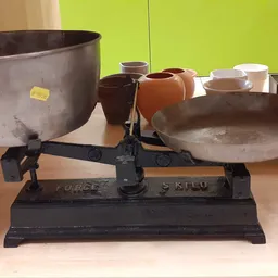 Oude mechanische balansweegschaal met twee metalen schalen en gewichtjes