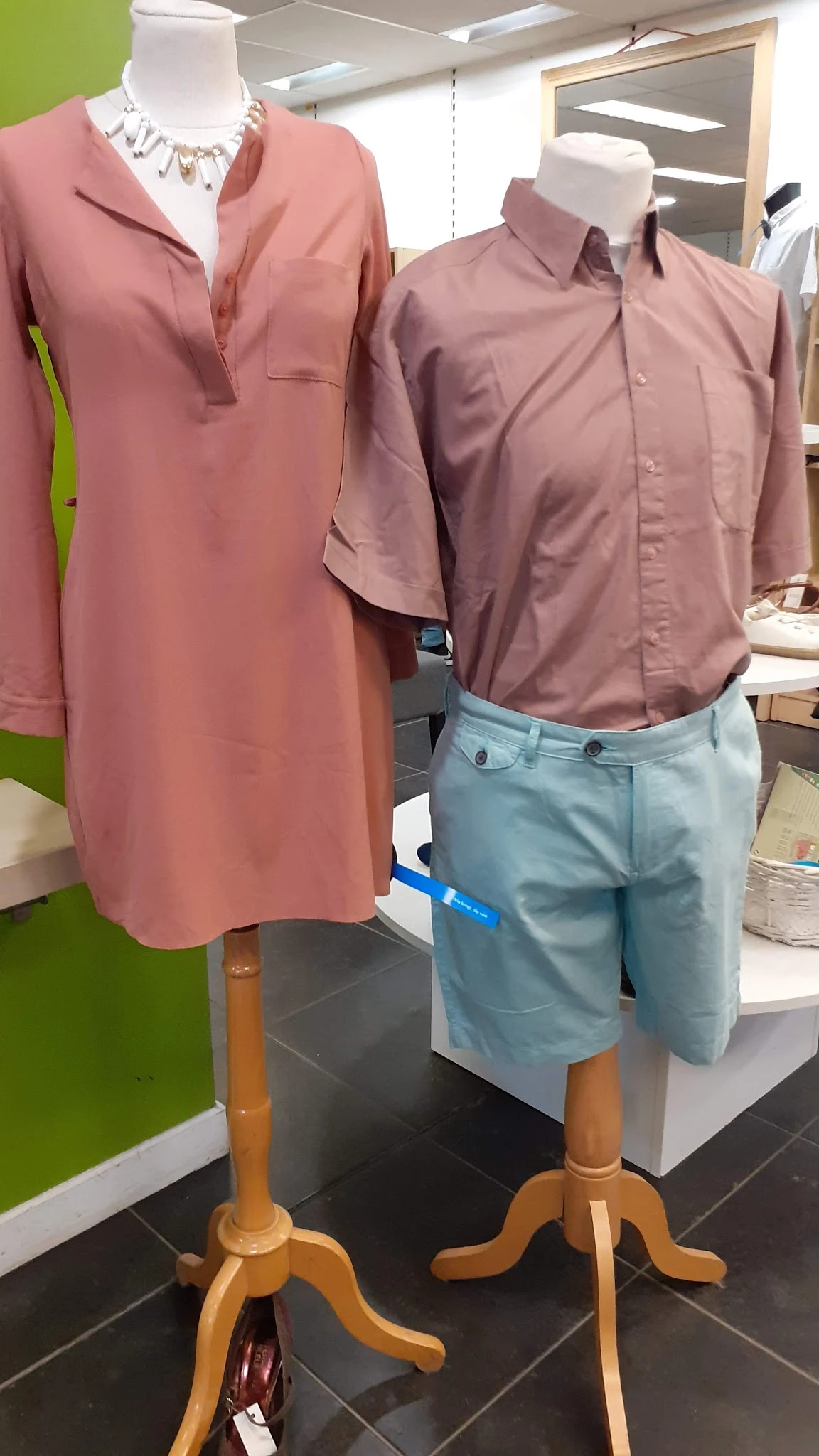 Uitgestalde herenkleding: roze en paarse overhemden en lichtblauwe broeken op mannequins