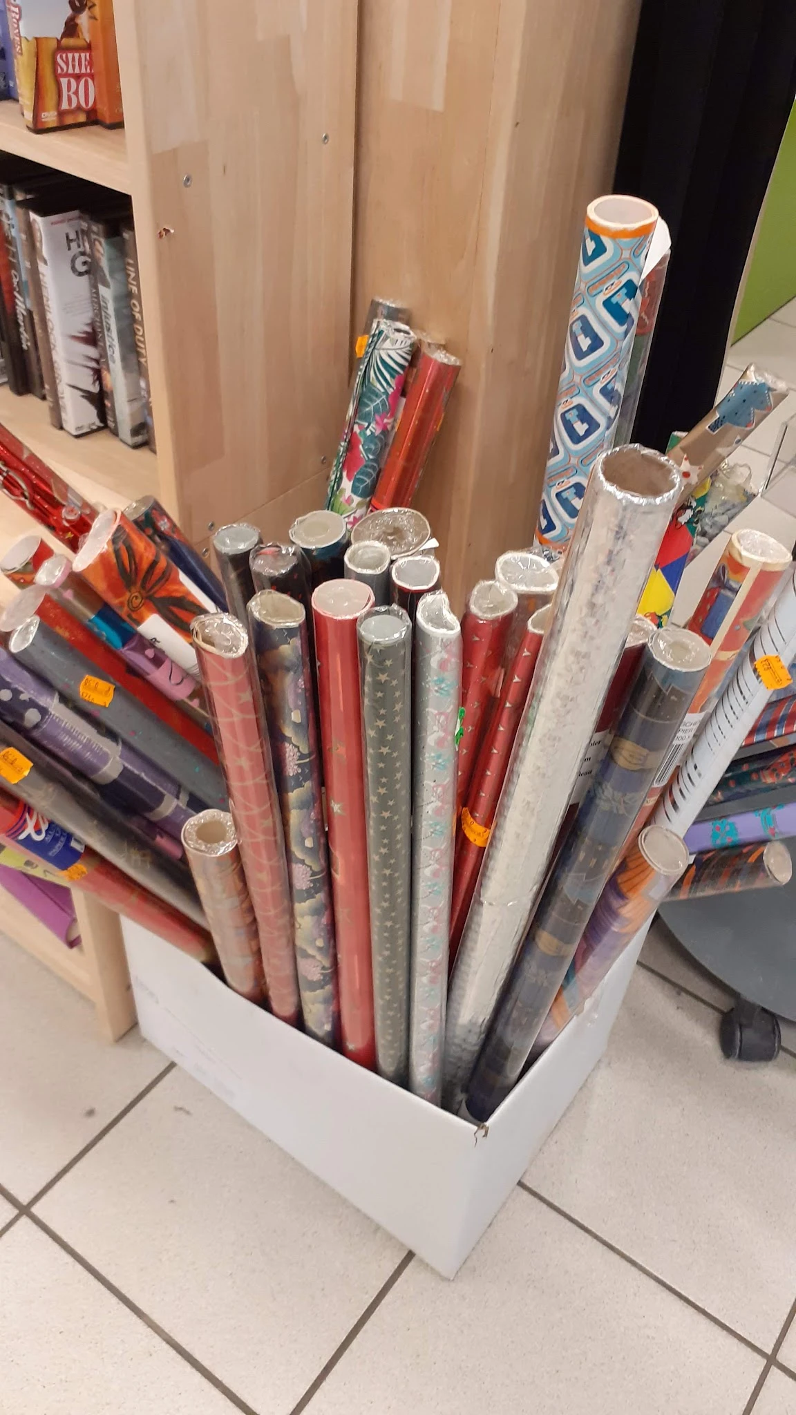 Uitgestalde rollen decoratief papier en behang in verschillende kleuren en patronen