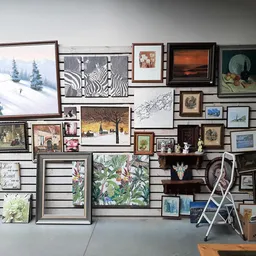 Slatwall met uitgestalde kunstwerken, lijsten, prints en decoratieve artikelen in verschillende formaten en stijlen