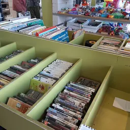Groene bakken met DVD's en cd's netjes uitgestald in kringloopwinkel
