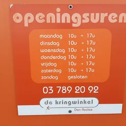 Oranje openingstijdenbord met weekdagen, openingsuren 10u-17u, telefoonnummer en winkelnaambord
