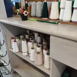 Stellingkast met nombreuses rollen garen en draden in verschillende kleuren