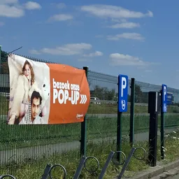 Oranje banner met 'Bezoek ons POP-UP' tekst en afbeeldingen van twee personen aan een hekwerk