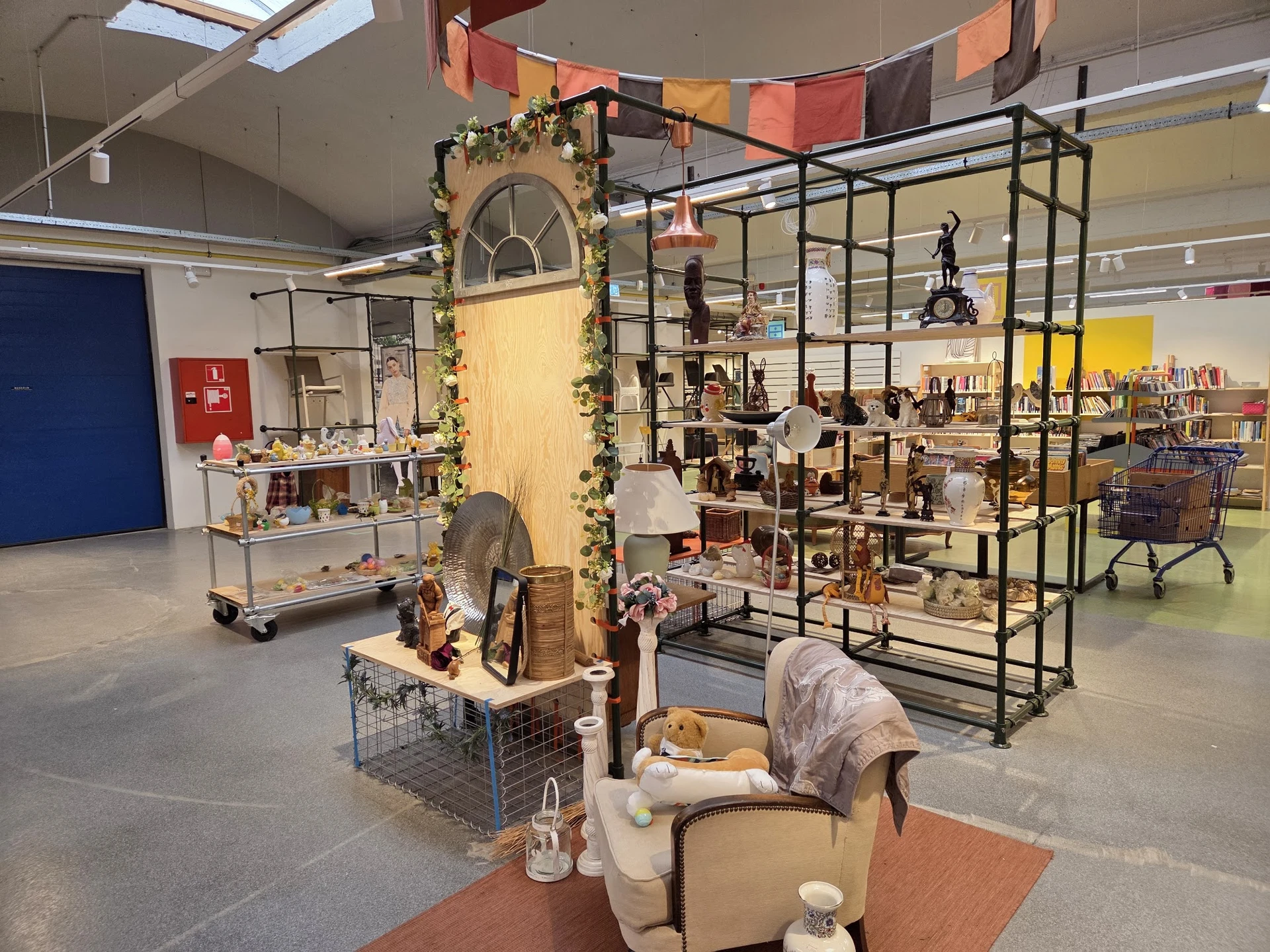 Winkelvloer met verschillende displaykasten, stellingen en uitgestalde spullen in een kringloopwinkel
