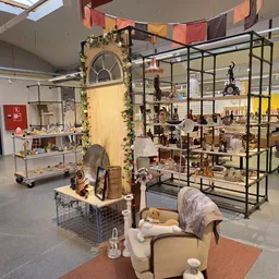 Winkelvloer met verschillende displaykasten, stellingen en uitgestalde spullen in een kringloopwinkel