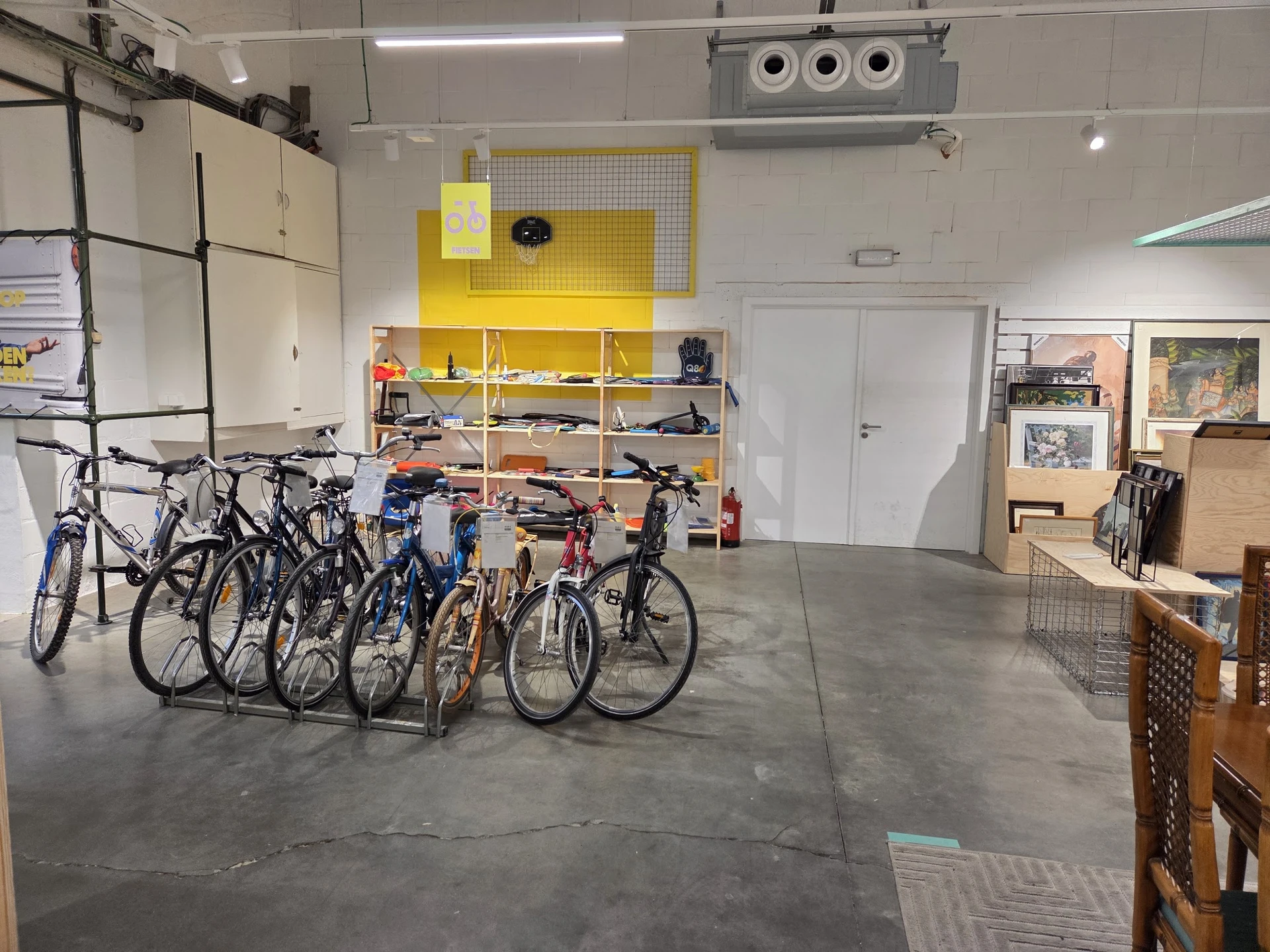 Verzameling tweedehands fietsen in diverse kleuren uitgestald in de winkelruimte