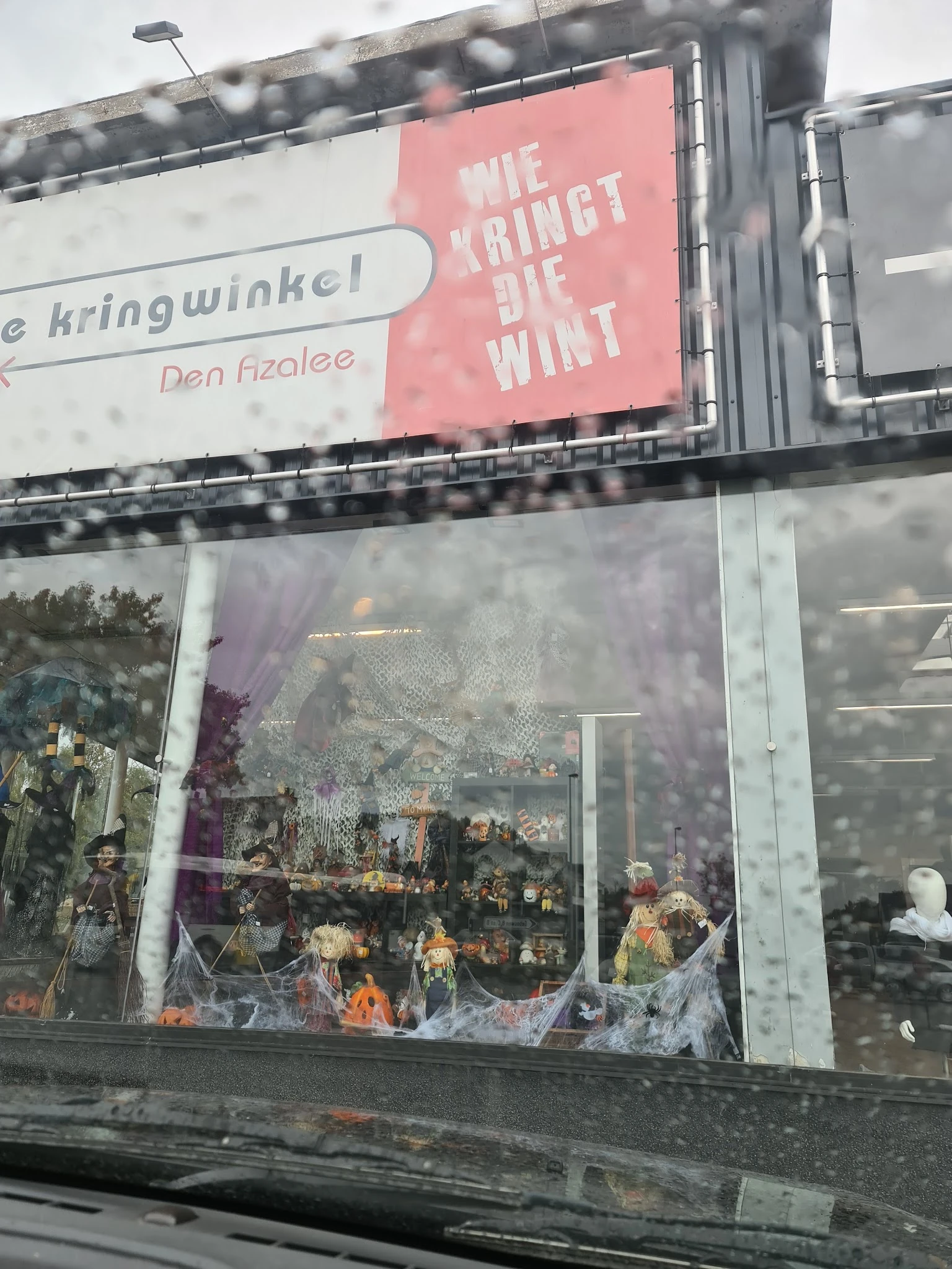 Winkelruit met paarse bloemen en silhouetten van mensen binnenin, advertentieborden bovenaan