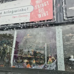 Winkelruit met paarse bloemen en silhouetten van mensen binnenin, advertentieborden bovenaan
