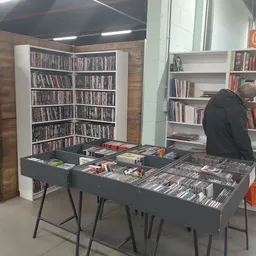 Uitstalling van dvd's en blu-rays op een tafel met boekenkast op achtergrond