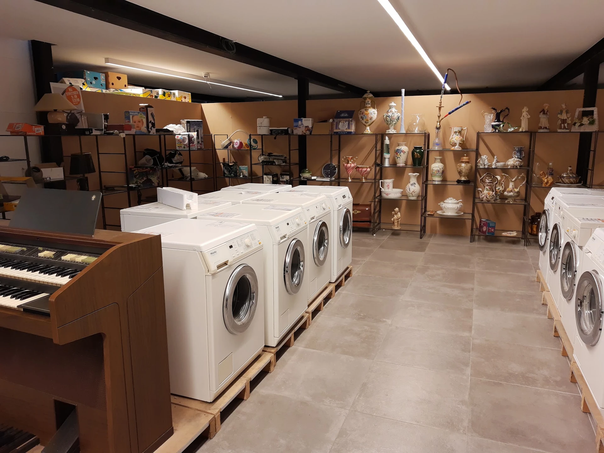 Winkelinterieur met wasmachines en diverse artikelen op stellingen