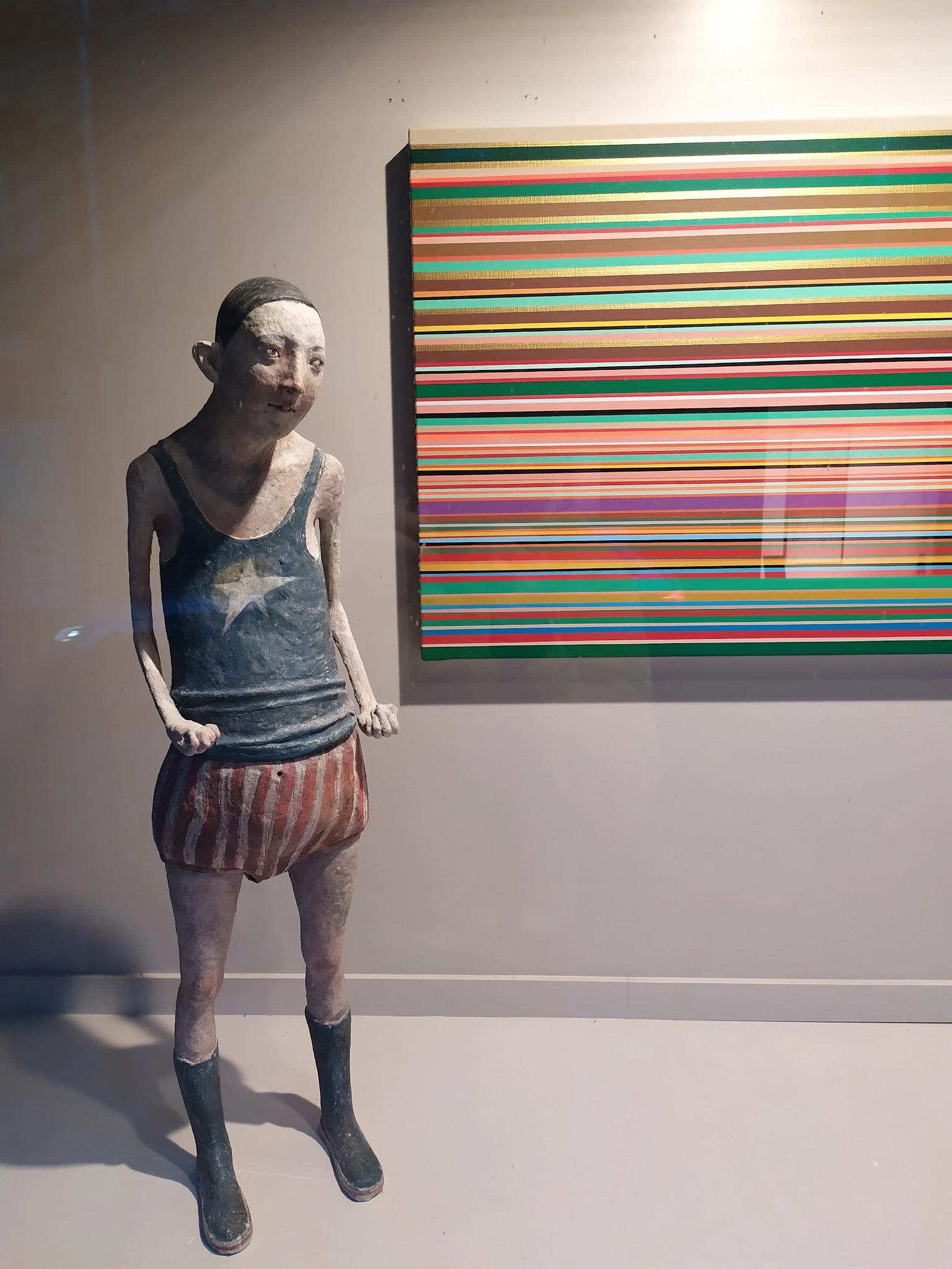 Kunstwerk van een figuur in een tank top met sterrenprint en gestreepte shorts