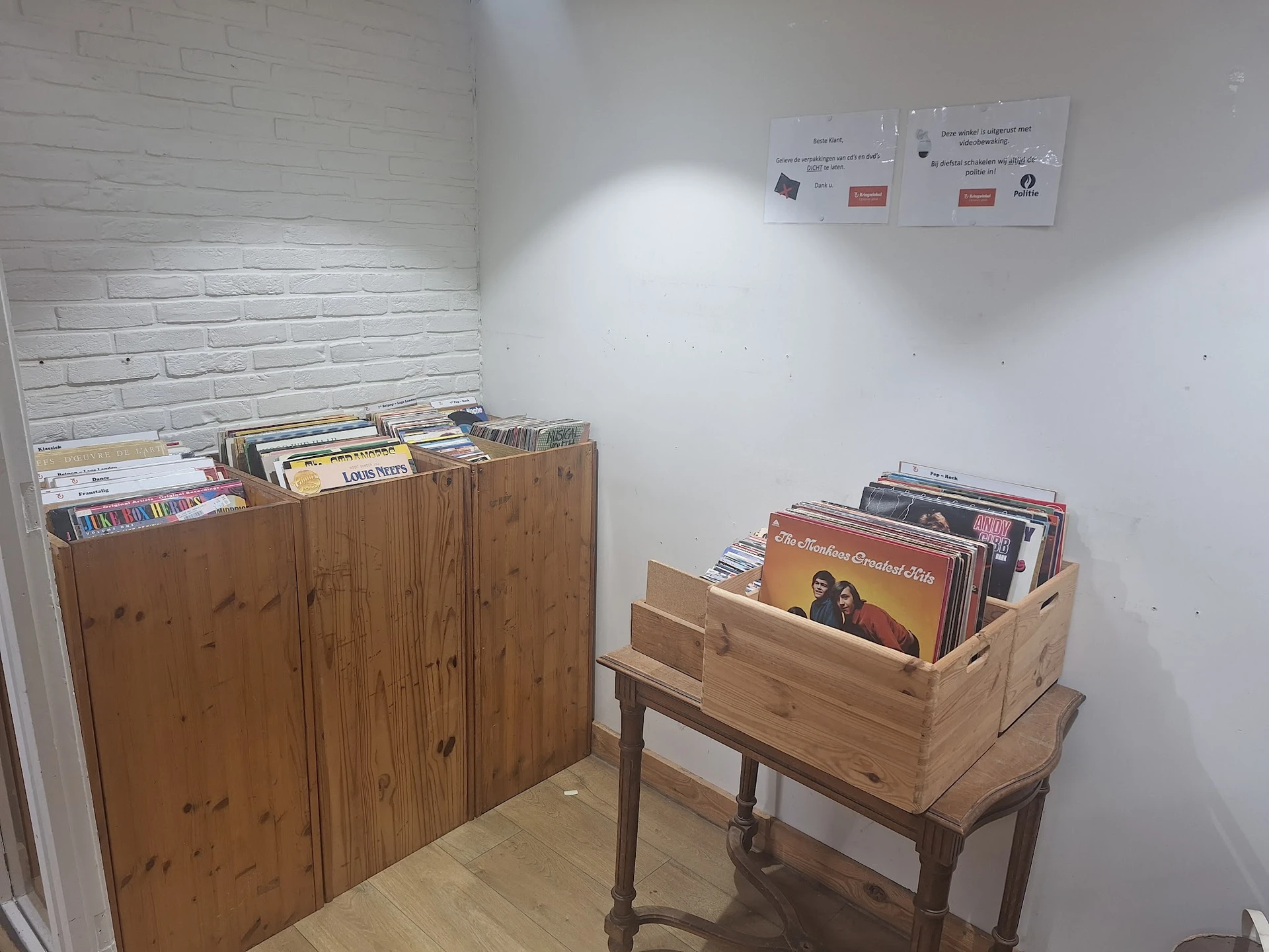 Houten kasten en rekken met vinyl records en cd's in een hoek van de winkel