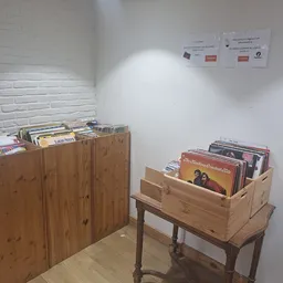 Houten kasten en rekken met vinyl records en cd's in een hoek van de winkel