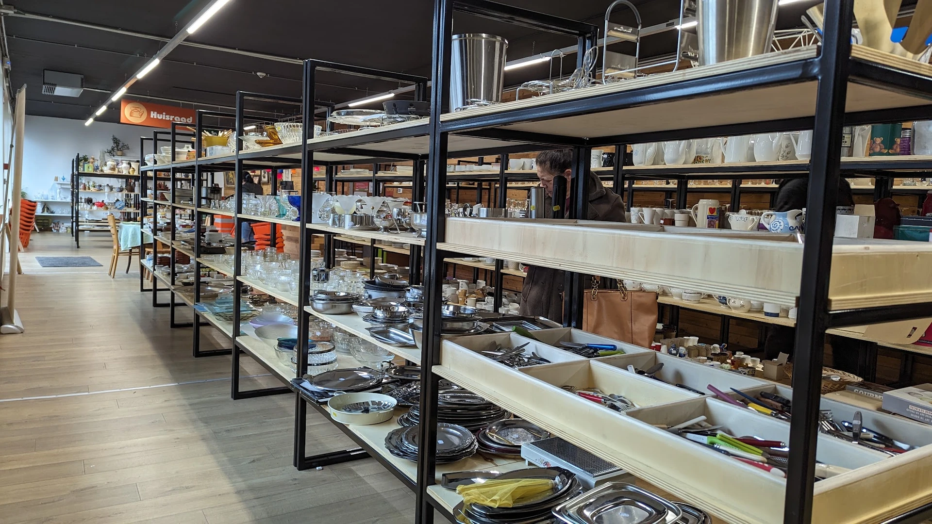 Glazen vitrinekasten met servies, borden, kopjes en ander huishoudelijk aardewerk op elkaar gestapeld