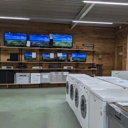 Witgoedafdeling met wasmachines en drogers uitgestald in de kringloopwinkel