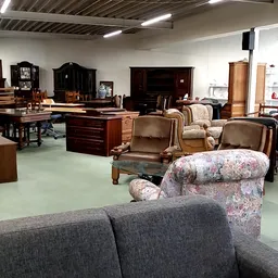 Winkelvloer met meubels: fauteuils, stoelen, kasten en houten tafels in verschillende stijlen