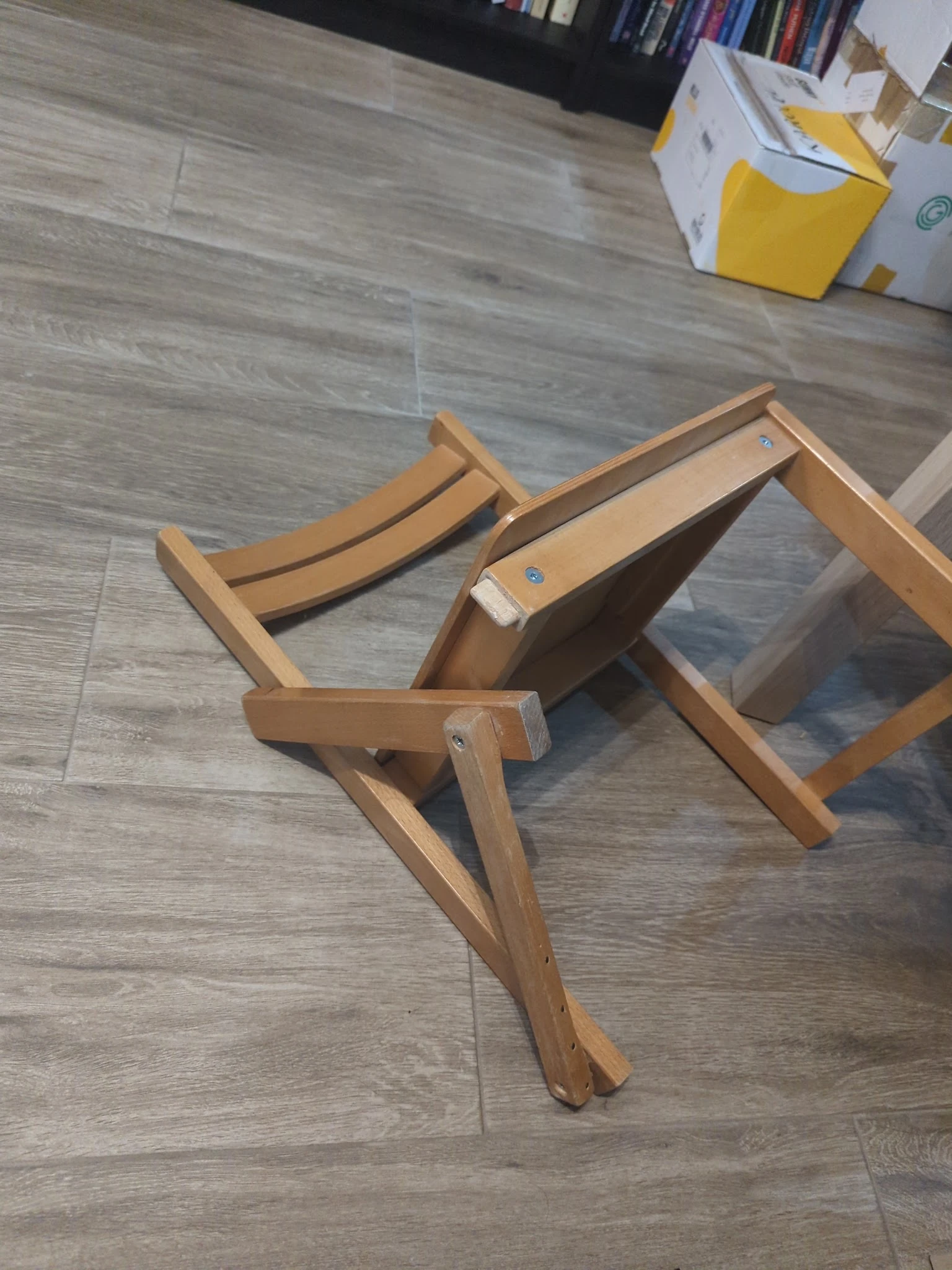 Houten ligstoel of campingstoel in ontvouwen positie op grijze vinyl vloer