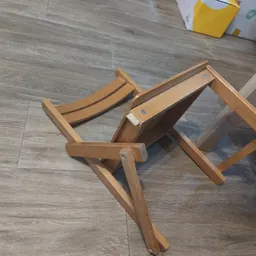 Houten ligstoel of campingstoel in ontvouwen positie op grijze vinyl vloer