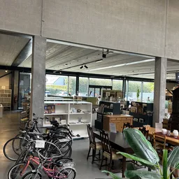 Winkelvloer met fietsen, meubels, plantenbakken en stellingen met spullen