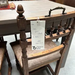 Houten stoel met prijskaartje aan de rugleuning waarop '3€ per stuk' is geschreven