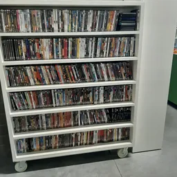 Witte boekenkast met zes schappen vol dvd's en blu-rays op wieltjes