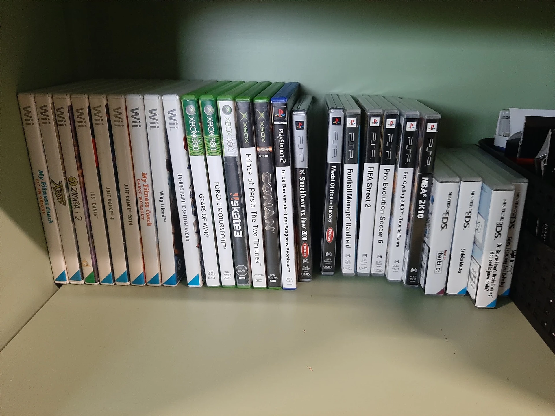 Rij van tweedehands dvd's en games op een plank, wit en zwart ingepakt