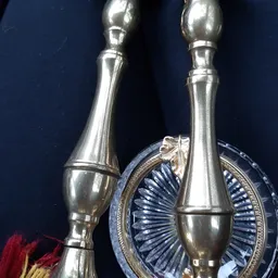 Twee zilveren decoratieve flesjes en een blauwe schelp-vormige schaal op donkerblauwe achtergrond