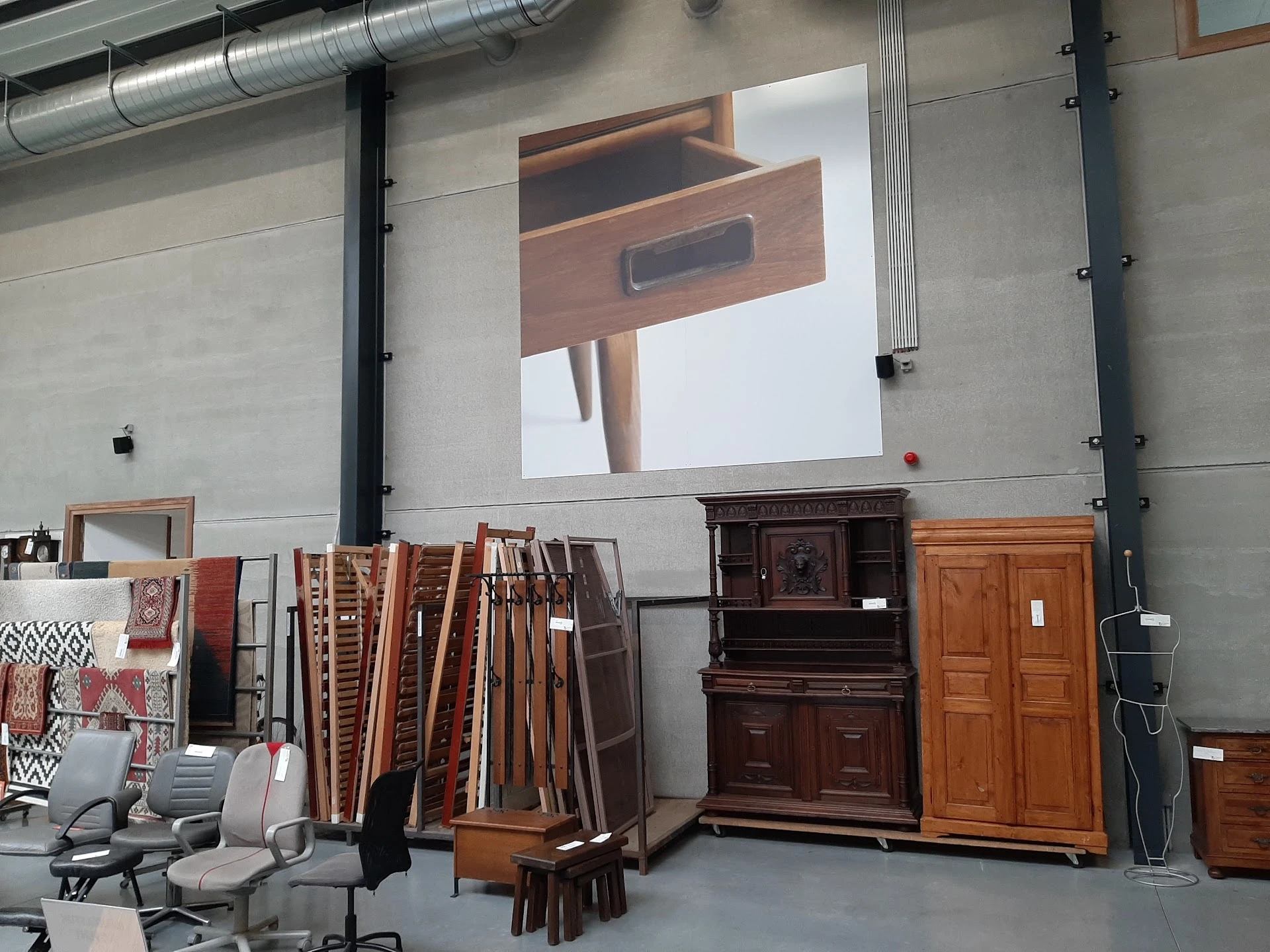 Magazijn met houten meubels, kasten en deelen tegen de muur, grote projectie op achtergrond