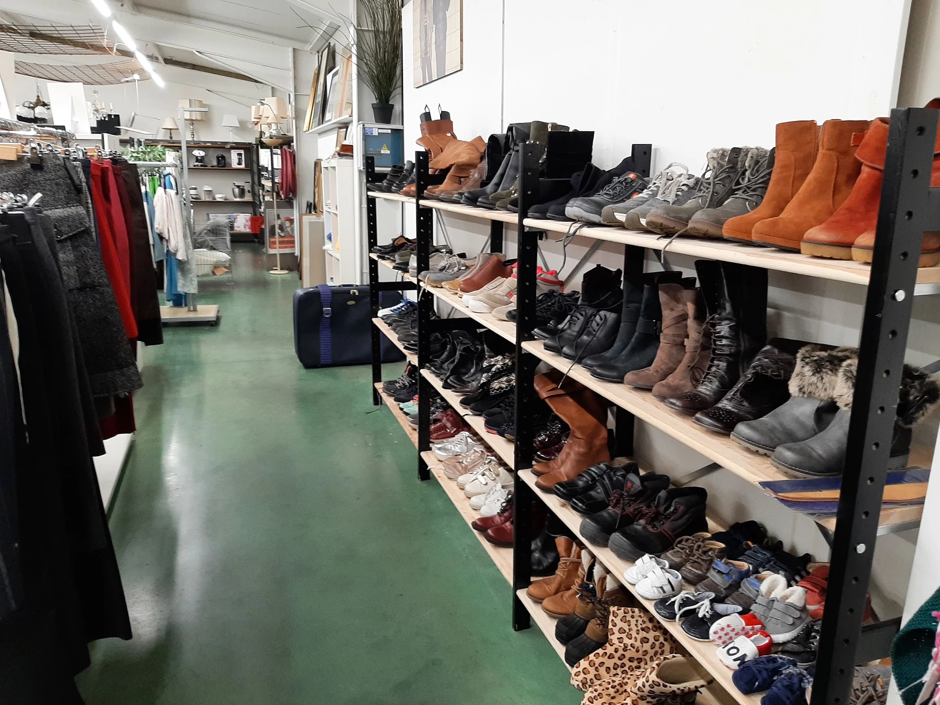 Stellingen met tweedehands schoenen en laarzen in diverse kleuren en stijlen