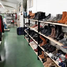 Stellingen met tweedehands schoenen en laarzen in diverse kleuren en stijlen