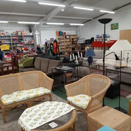 Winkelinterieur met rieten meubels, banken, boekenkasten en diverse tweedehands spullen