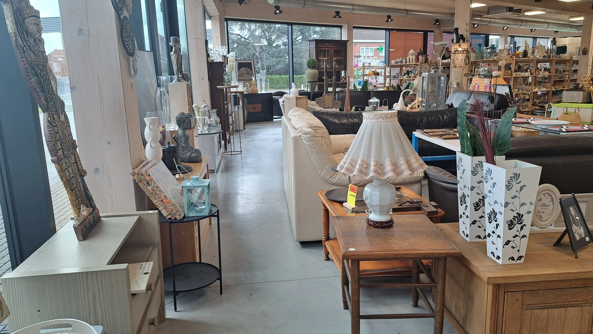 Winkelvloer van kringloopwinkel met meubels, decoraties en diverse spullen langs de zijkanten