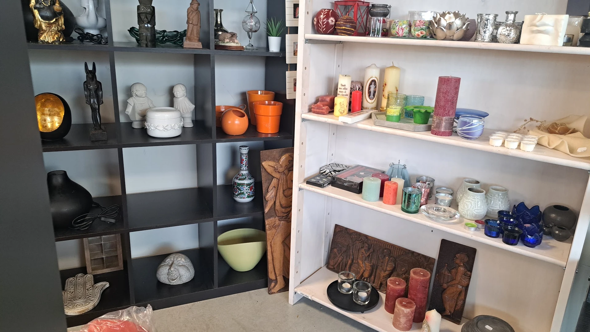 Twee открытые wandkasten met kaarsen, huisdecoratie en andere thriftstoreartikelenuitgestald