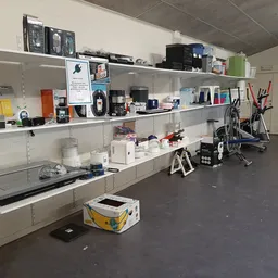 Stellingen met elektronische apparaten, printers, computers en diverse huishoudelijke artikelen