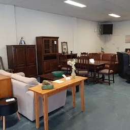 Winkelvloer met meubels zoals kasten, stoelen, tafels en een bank uitgestald