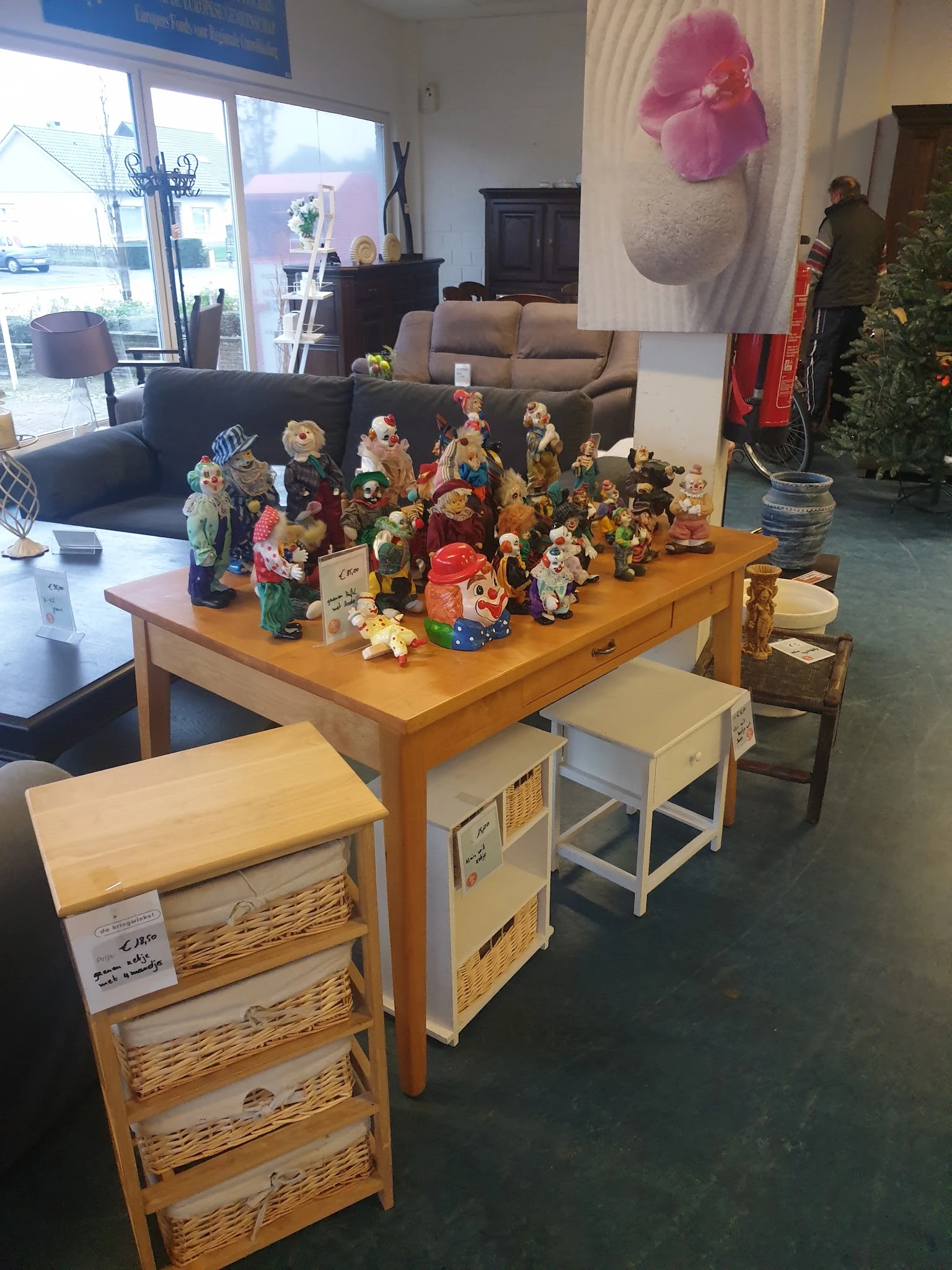 Houten tafel met diverse decoratieve beeldjes, poppen en huishoudelijke artikelen uitgestald
