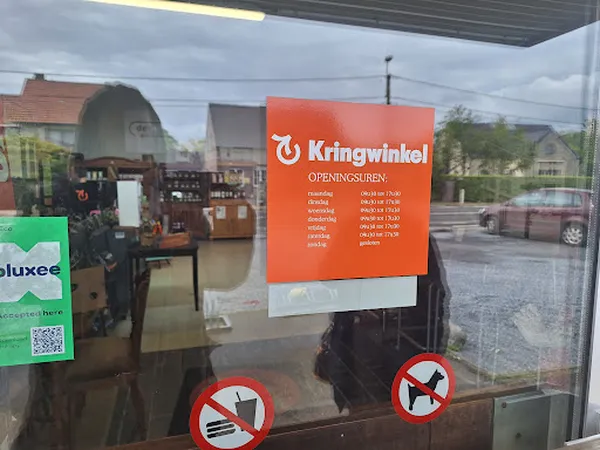 Winkelruit met oranje Kringwinkel-bord met openingstijden en twee verbodsborden voor honden