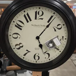 Zwarte wandklok Sterling & Noble met Romeinse cijfers, wijzers gericht op ongeveer 4 uur