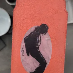 Close-up van een rood boek of object met een zwart-wit portretafbeelding van een persoon op het omslag